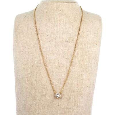 un collier à chaîne en or avec un pendentif en diamant sur un mannequin