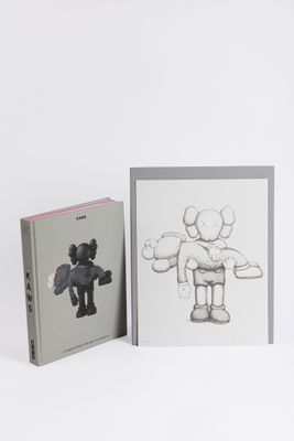 two books on a white surface with a drawing of a person