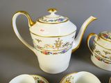 quatre tasses et une théière posées sur une table