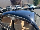 a black car parked in a parking lot with other cars in the background