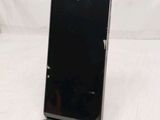 the back of a black cell phone sitting on top of a white table
