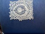 a blue chair with a white doily on it