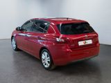 the back of a red car is parked in a large room