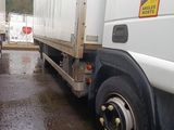 two semi trucks parked side by side in the rain