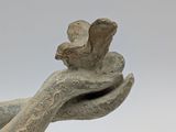 sculpture of a hand holding a bird on a white background