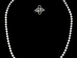 un ensemble composé d'un collier et de boucles d'oreilles en perles blanches