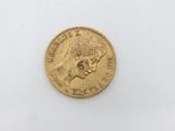 a close up of a gold coin on a white surface