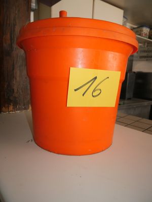 un seau orange sur lequel est posée une note, posé sur un comptoir
