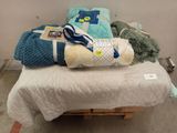 un tas de couvertures posé sur un lit dans une chambre