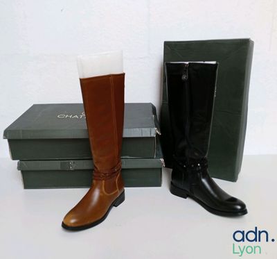 a pair of boots sitting next to a box of books
