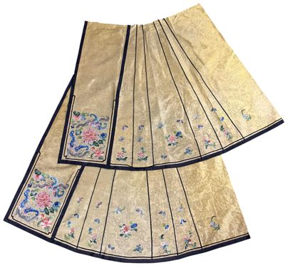 two pieces of gold cloth with blue trims and flowers on them