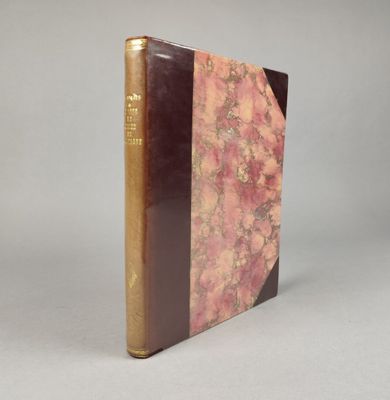 un vieux livre posé sur une table blanche à côté d'un mur gris
