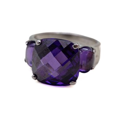 une image d'un gros plan d'une bague avec une pierre violette