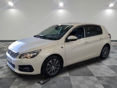 une voiture blanche est garée dans une pièce au sol à carreaux