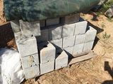 cement blocks stacked on top of each other on a dirt ground