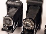 two old cameras sitting next to each other on a table