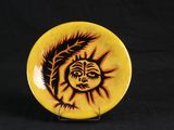 a yellow plate with a black and orange design on it