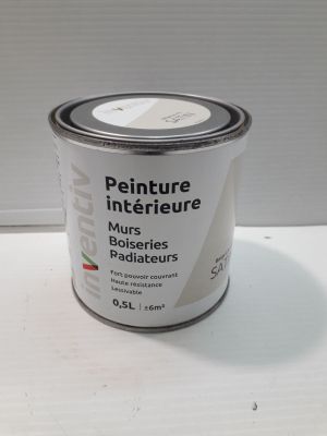 a can of paint sitting on a white table