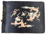 un vieux livre dont la couverture est ornée d'un dragon