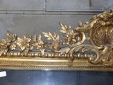 a mirror with a gold decoration on it in a room