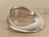 sterling silver ring with engraved message on it on a wooden surface