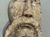 a stone sculpture of a face on the wall