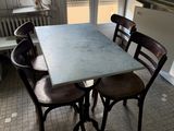 a table and four chairs in a small room