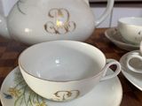 a tea pot and two cups on a wooden table
