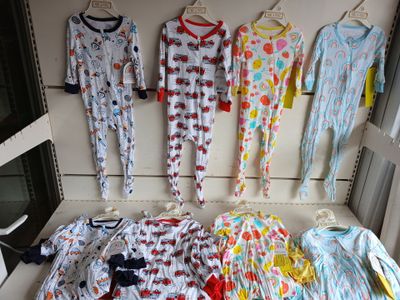 a lot of baby clothes hanging on the wall