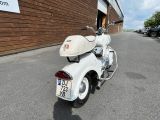 a white motor scooter parked in front of a building