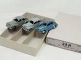 three toy cars in a box on a white surface