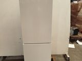 a white refrigerator sitting on a pallet in a warehouse