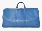 a blue duffel bag sitting on top of a white surface