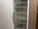 a refrigerator that is open in the corner of a room