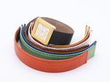 a lot of belts with a watch on top of them