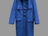 Le manteau est bleu et comporte des boutons au niveau du col.