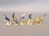 cinq figurines d'oiseaux alignées sur une table