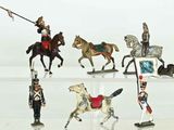 several figurines of toy soldiers on display on a white surface