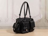 black leather handbag sitting on a wooden floor in front of a white wall