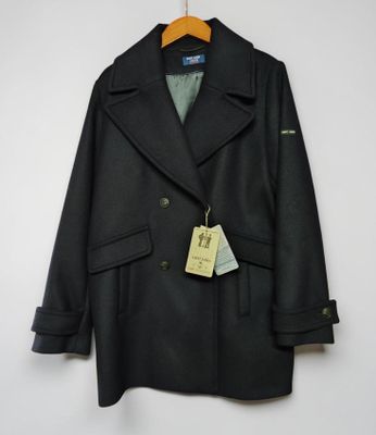 un manteau noir en peale suspendu à un cintre accroché au mur