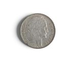 an old silver coin on a white surface with a white background
