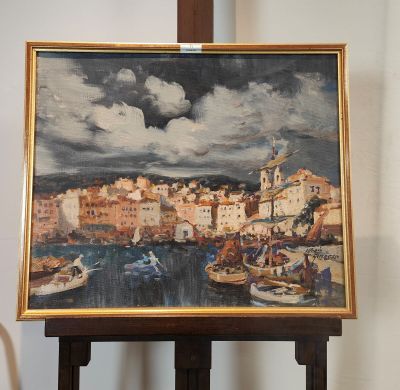 un tableau posé sur un chevalet, avec une vue de ville en arrière-plan