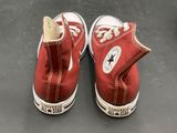 pair of red converse sneakers with white laces on a gray surface