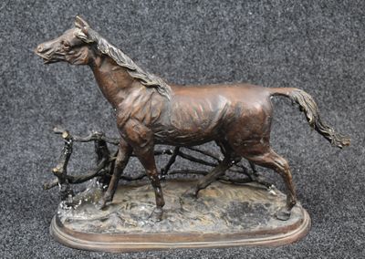 a bronze statue of a horse and a man on a cart