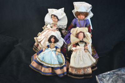 three dolls that are sitting next to each other on a black background
