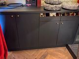 a picture of a kitchen with a wooden floor and black cabinets