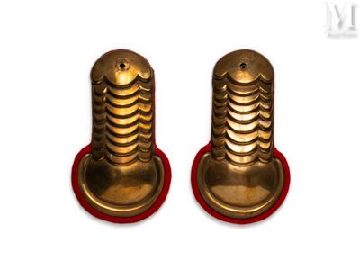 two brass screws on a red stand on a white surface