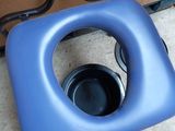 a blue toilet seat with a black bowl in it
