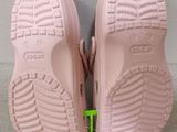 the soles of a pair of pink children ' s shoes with a green shoelace