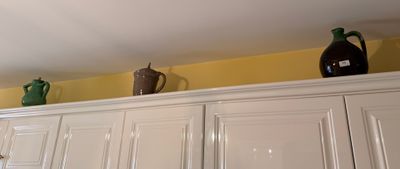 three vases on top of the cabinets in the kitchen